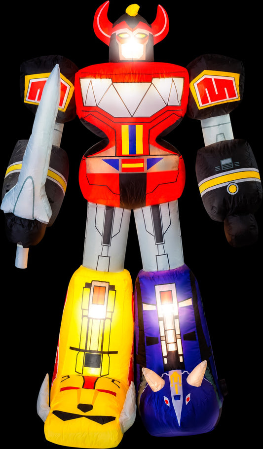 A large inflatable robot toy resembling a Zorro-style hero, shown against a black background. The figure has a red torso and head with glowing white eyes, black arms with yellow bands, a white sword on the right arm, and two large colorful legs: one yellow with a cat face graphic and one blue with a bird face graphic.