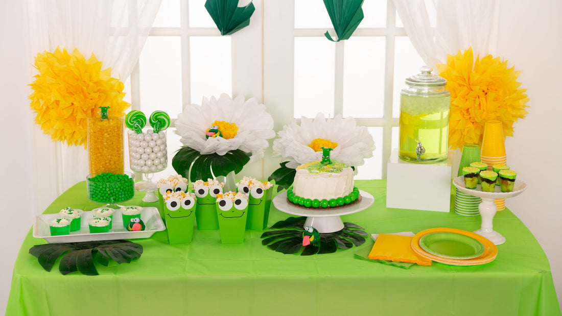 Frog-themed party dessert table with green treats, popcorn boxes, candy jars, and playful decorations for a fun kids birthday celebration.