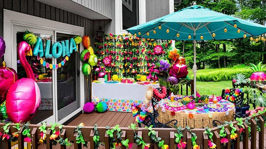 Colorful outdoor party setup with 'Aloha' sign, balloons, and decorations.