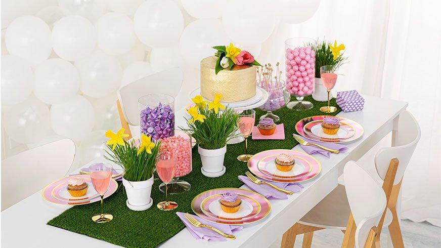 Decorative table setting with flowers, cake, and pastel colors on a white background