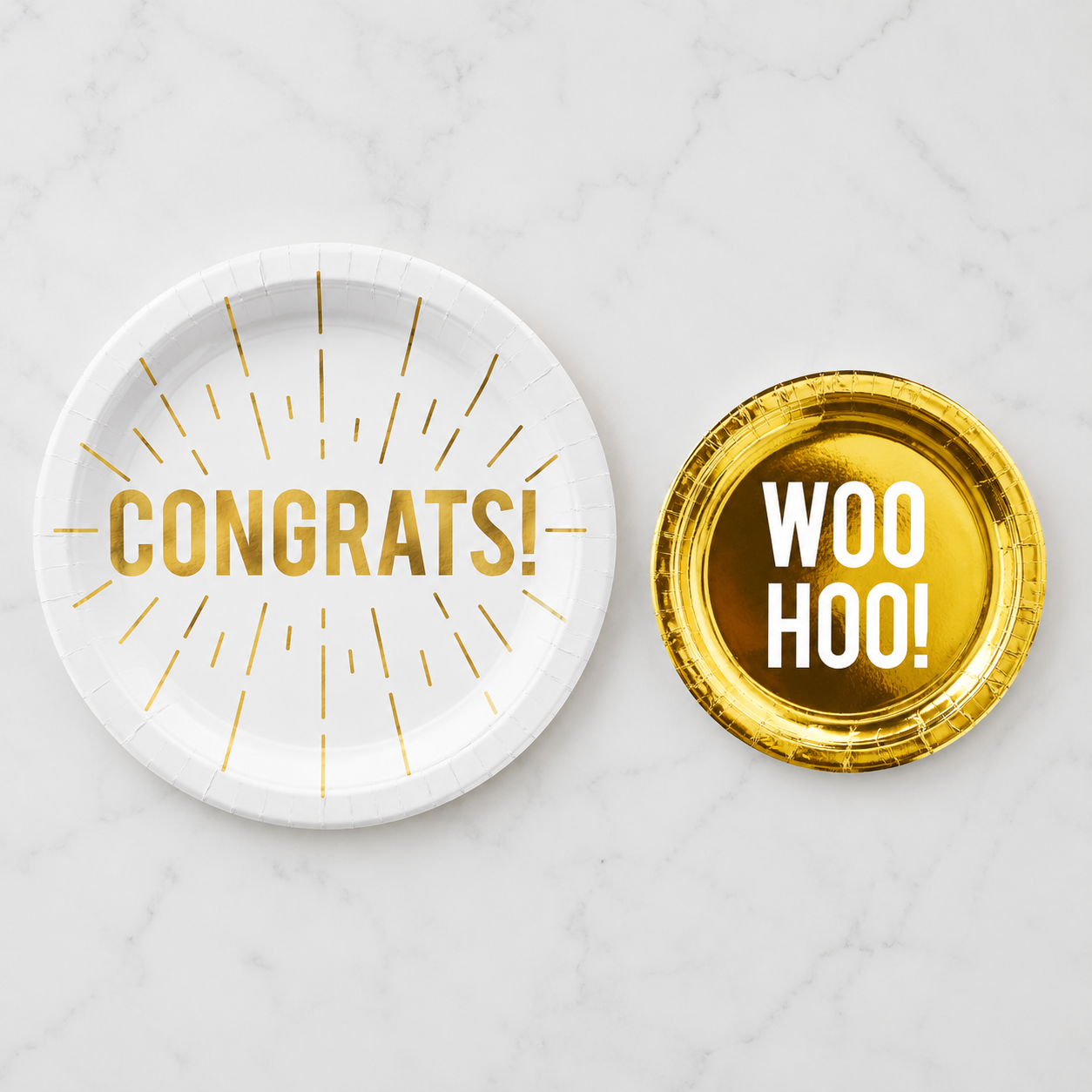 Two party plates with 'CONGRATS!' and 'WOO HOO!' text on a white surface.