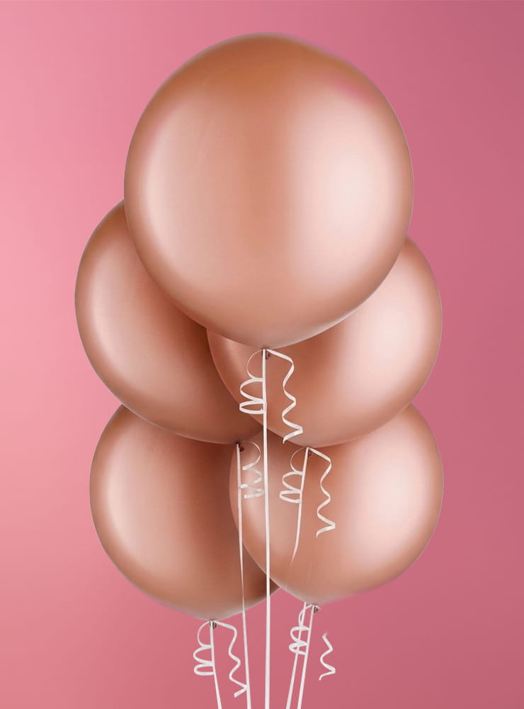 A cluster of five metallic rose gold balloons with curly white ribbons against a pink gradient background.
